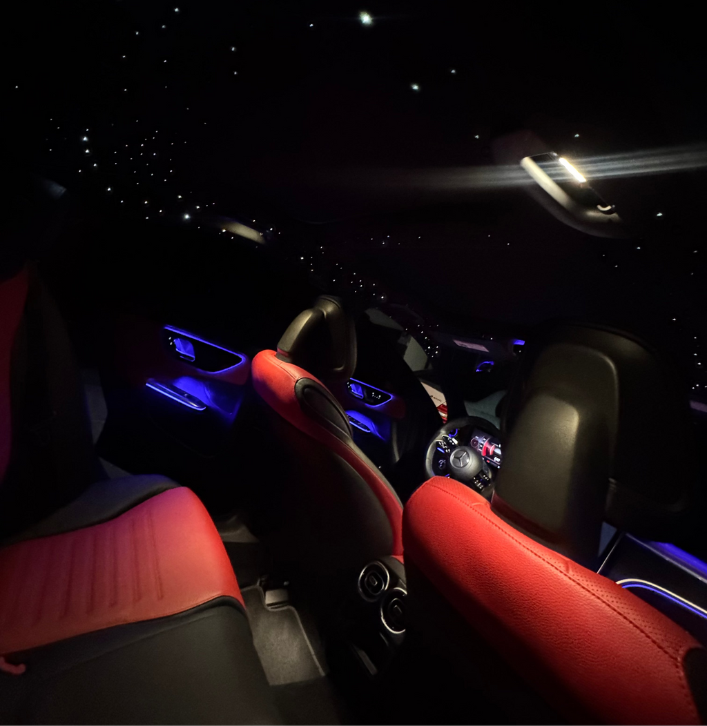 Car interior with red seats and dashboard lights at night