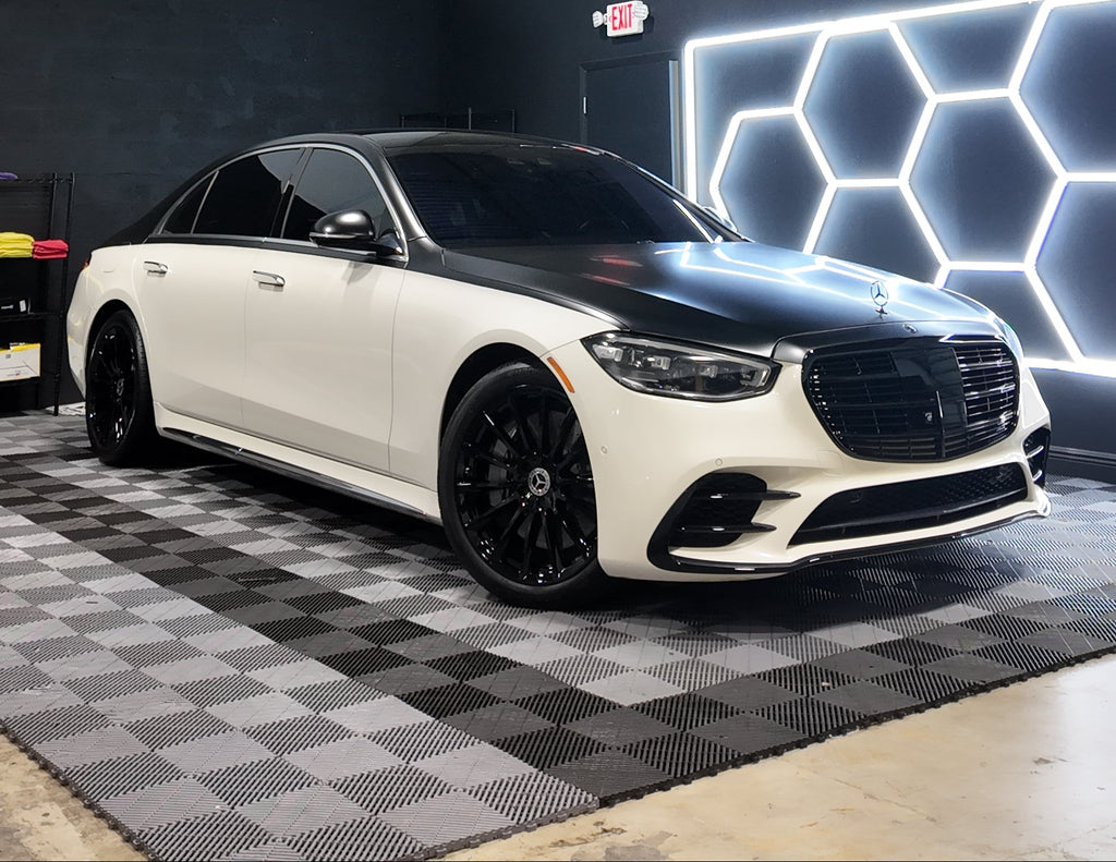 White luxury car in a warehouse setting with geometric light installation