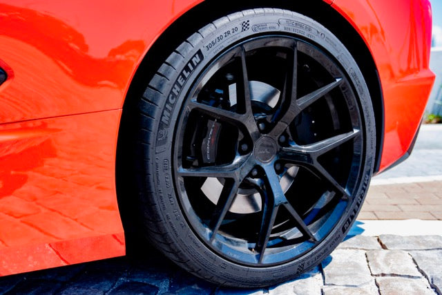 Close-up of a black car wheel on a red car