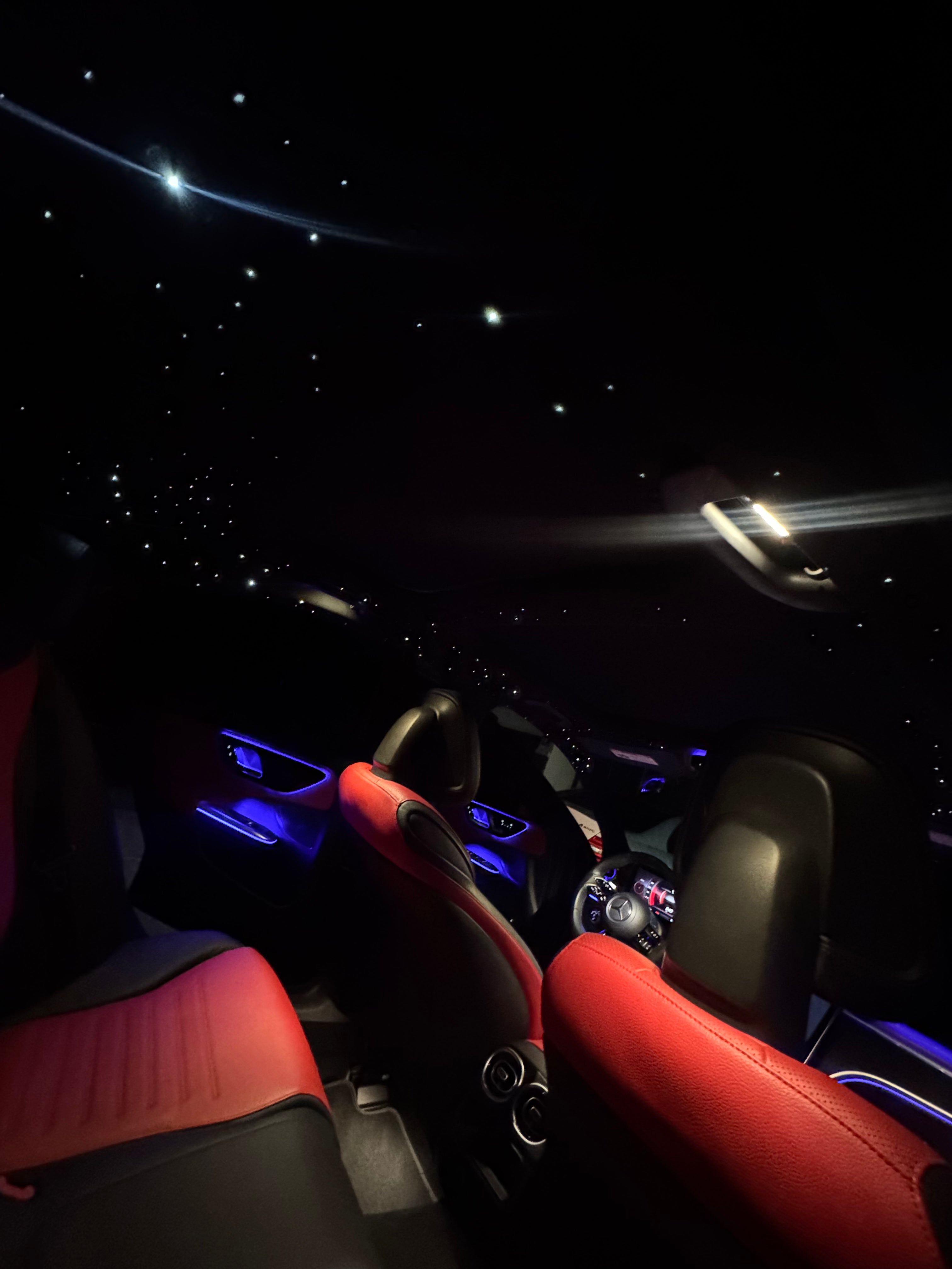 Car interior with red seats and dashboard lights at night