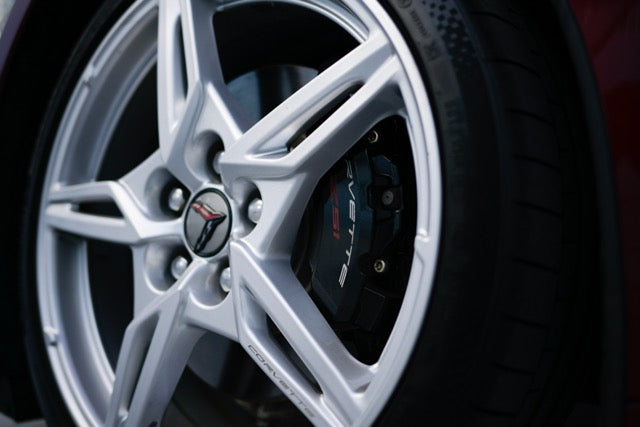 Close-up of a car wheel with a visible brand logo on a dark background