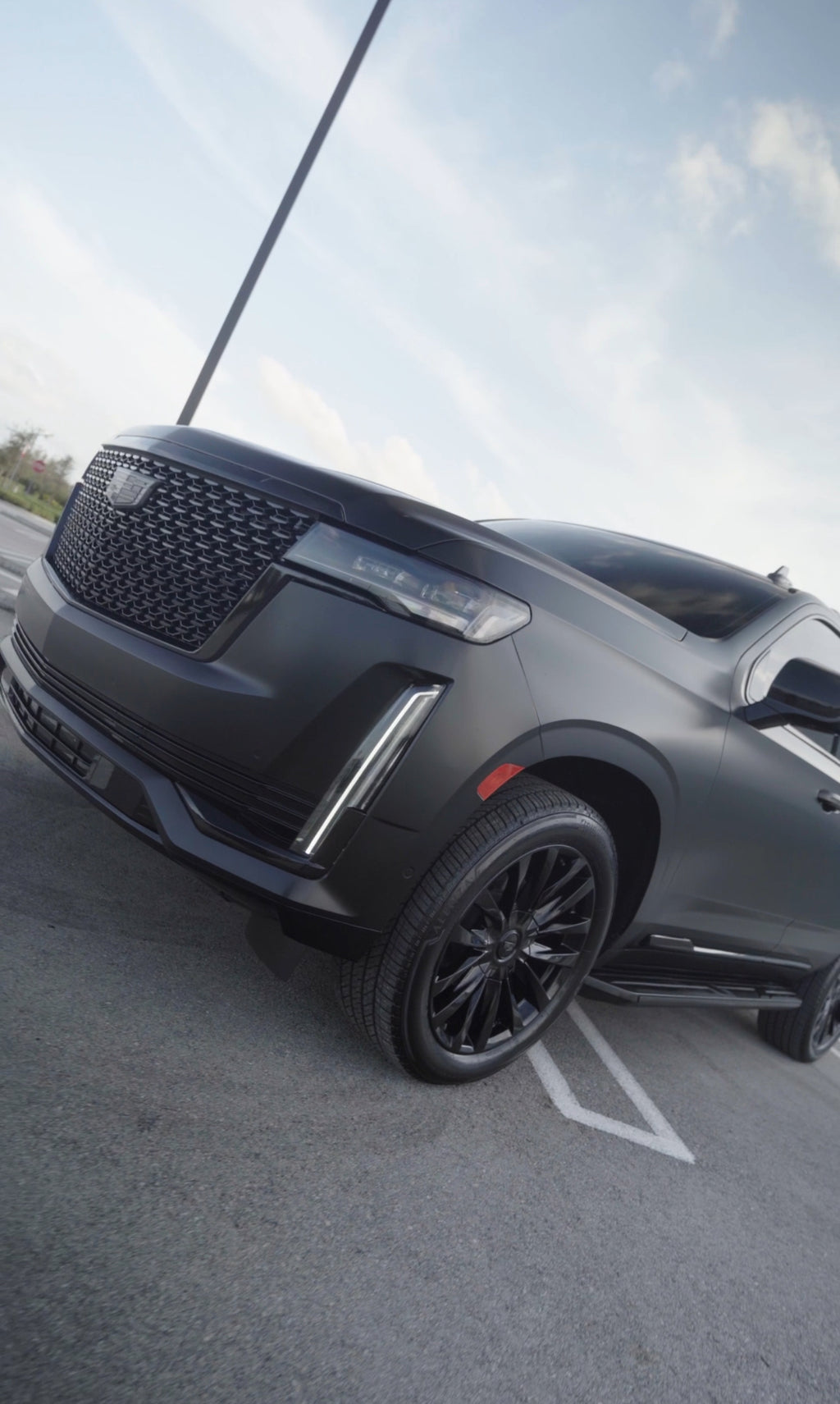 Gray SUV parked on a paved surface with a clear sky background