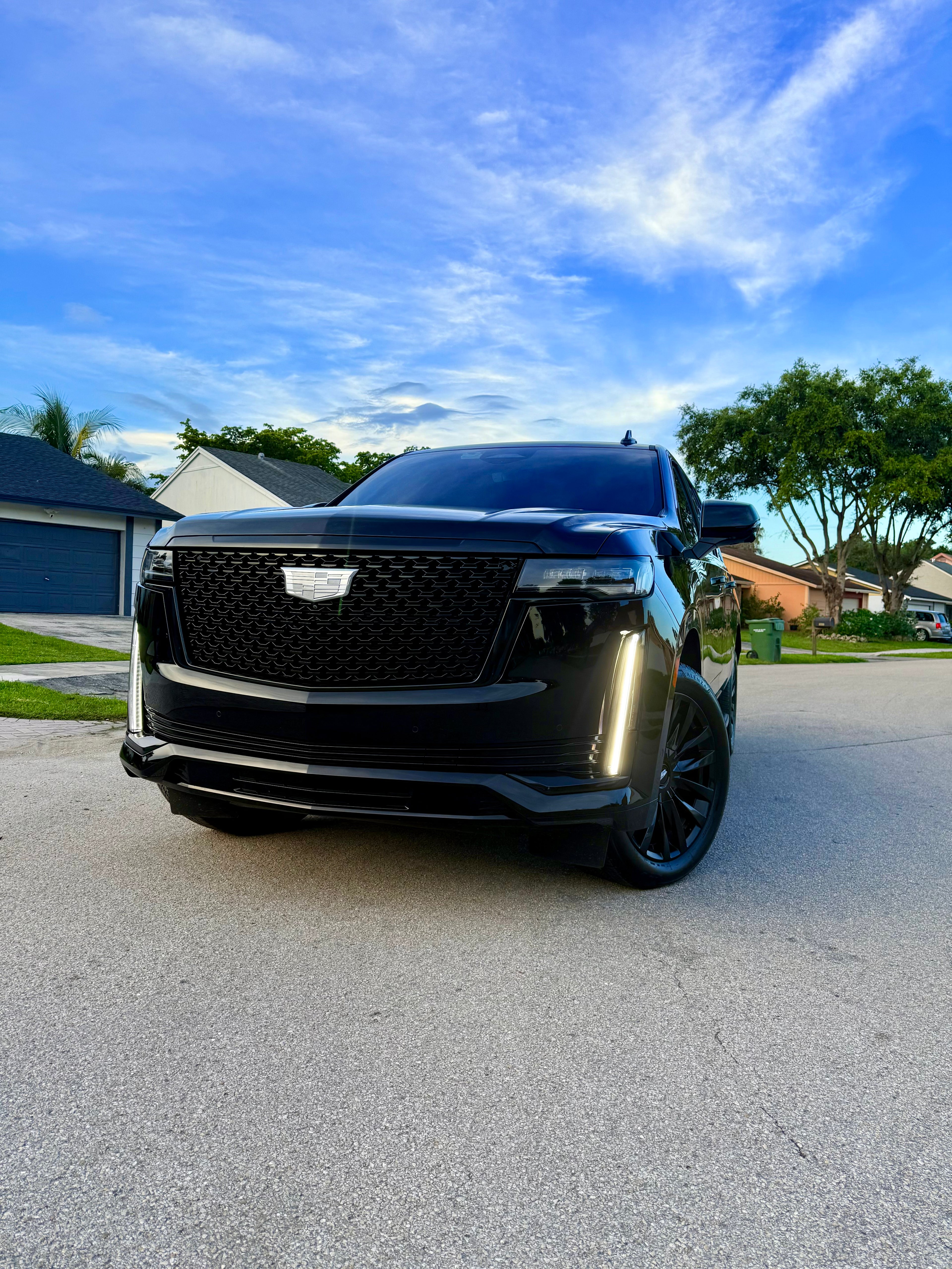 Black SUV parked on a driveway with a clear blue sky