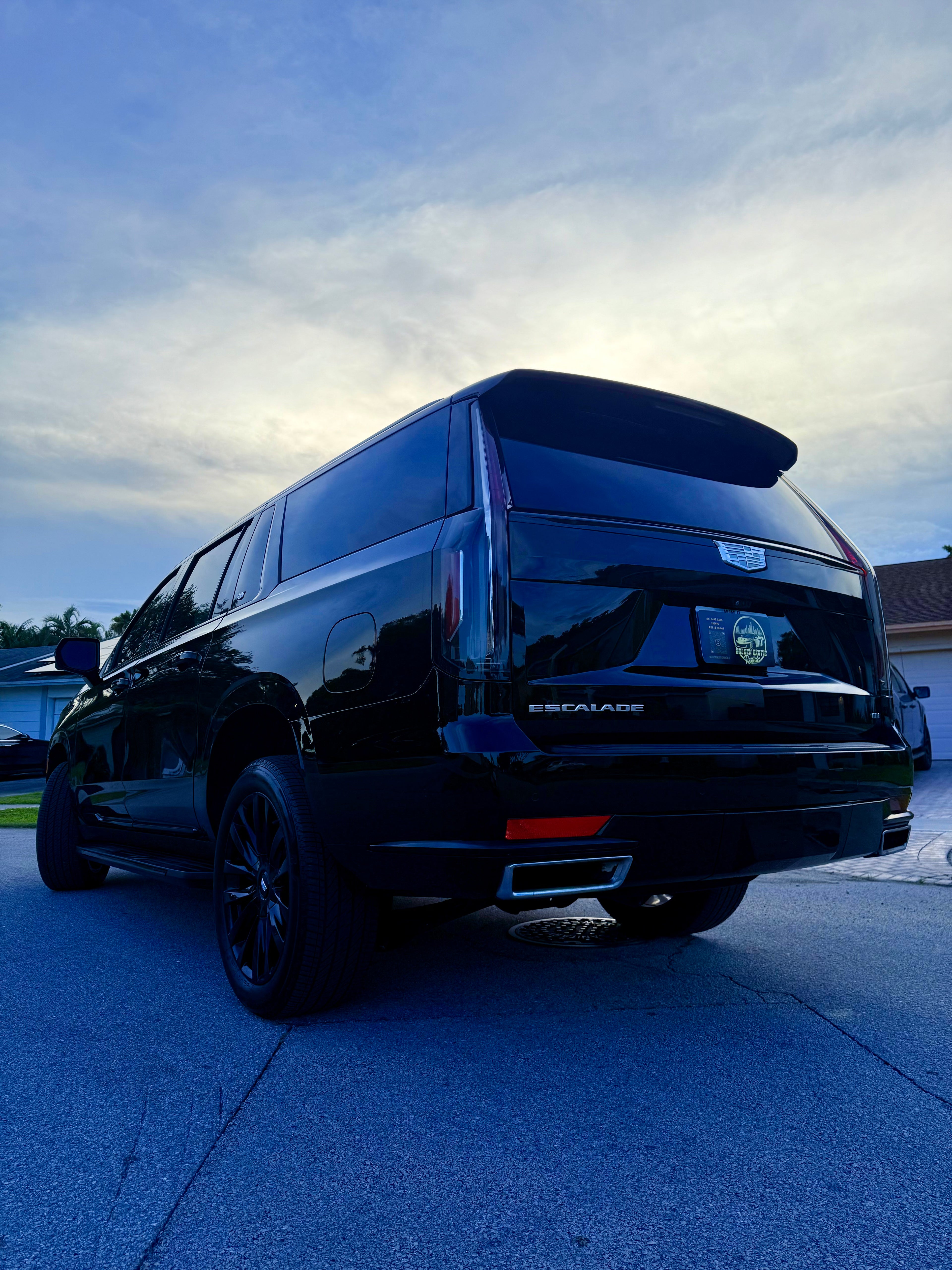 Black van parked on a concrete surface with a blue sky in the background