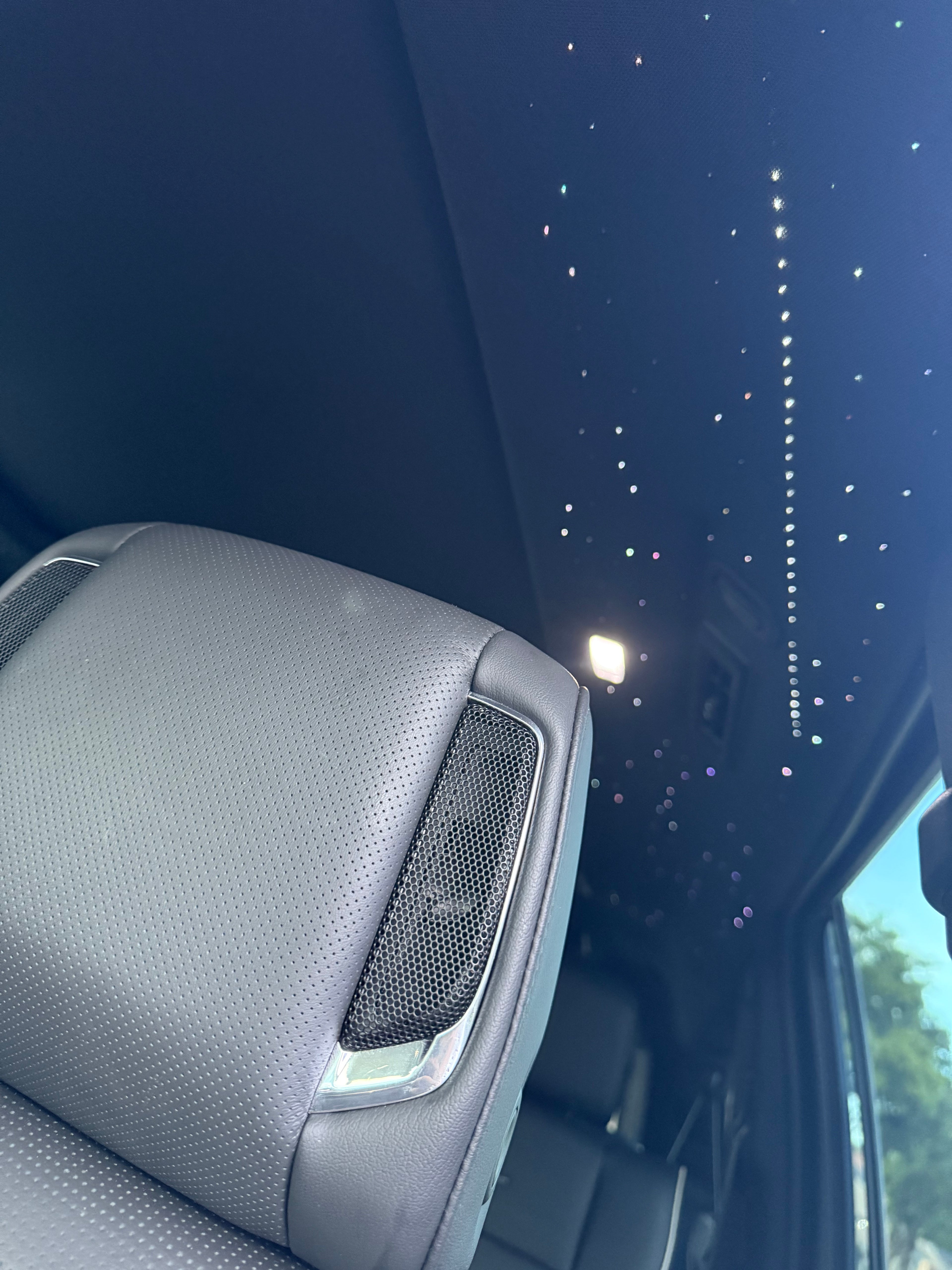Car interior with a speaker and starry sky view through the window