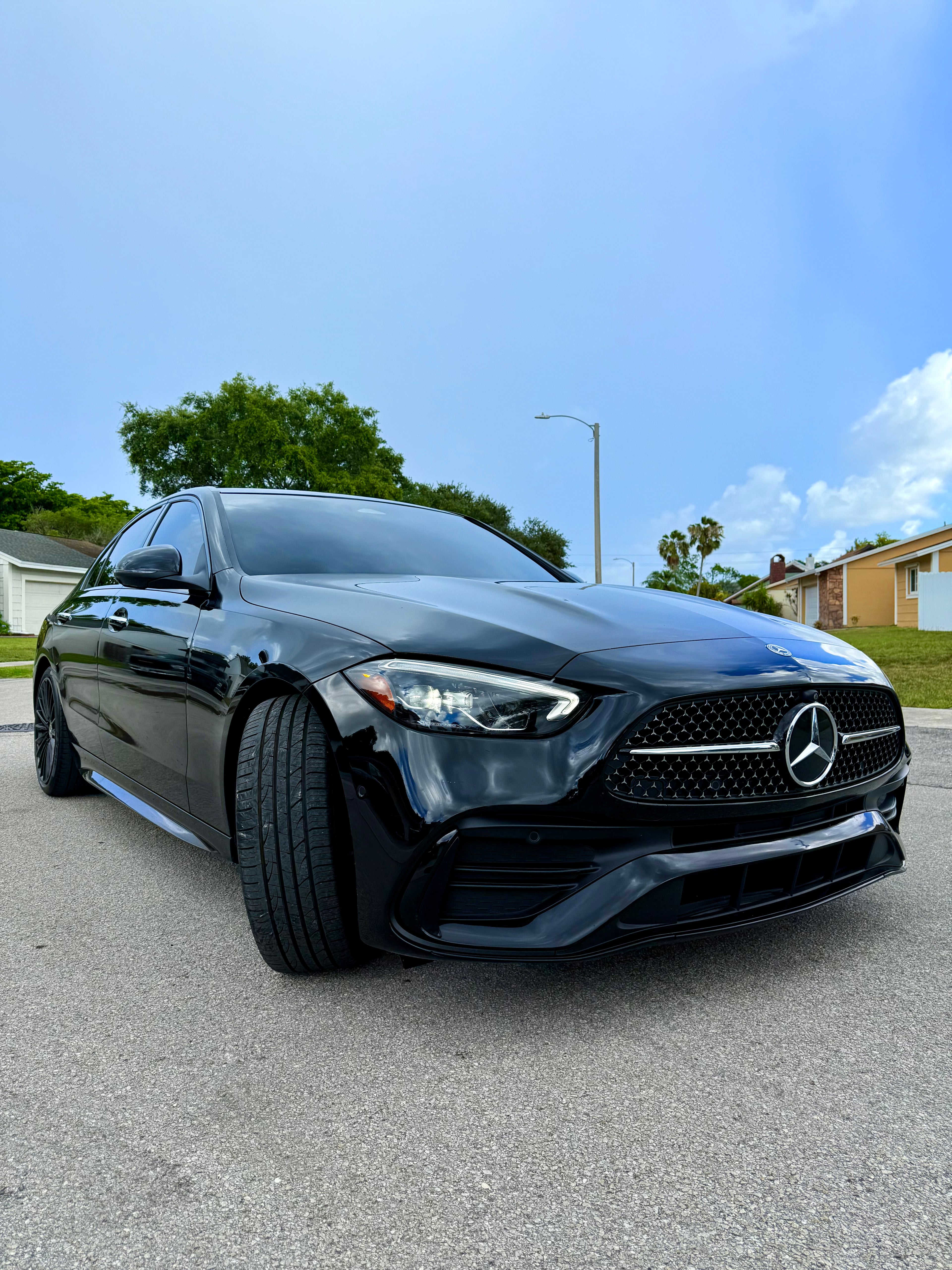 Black Mercedes-Benz car on a road with a clear blue sky