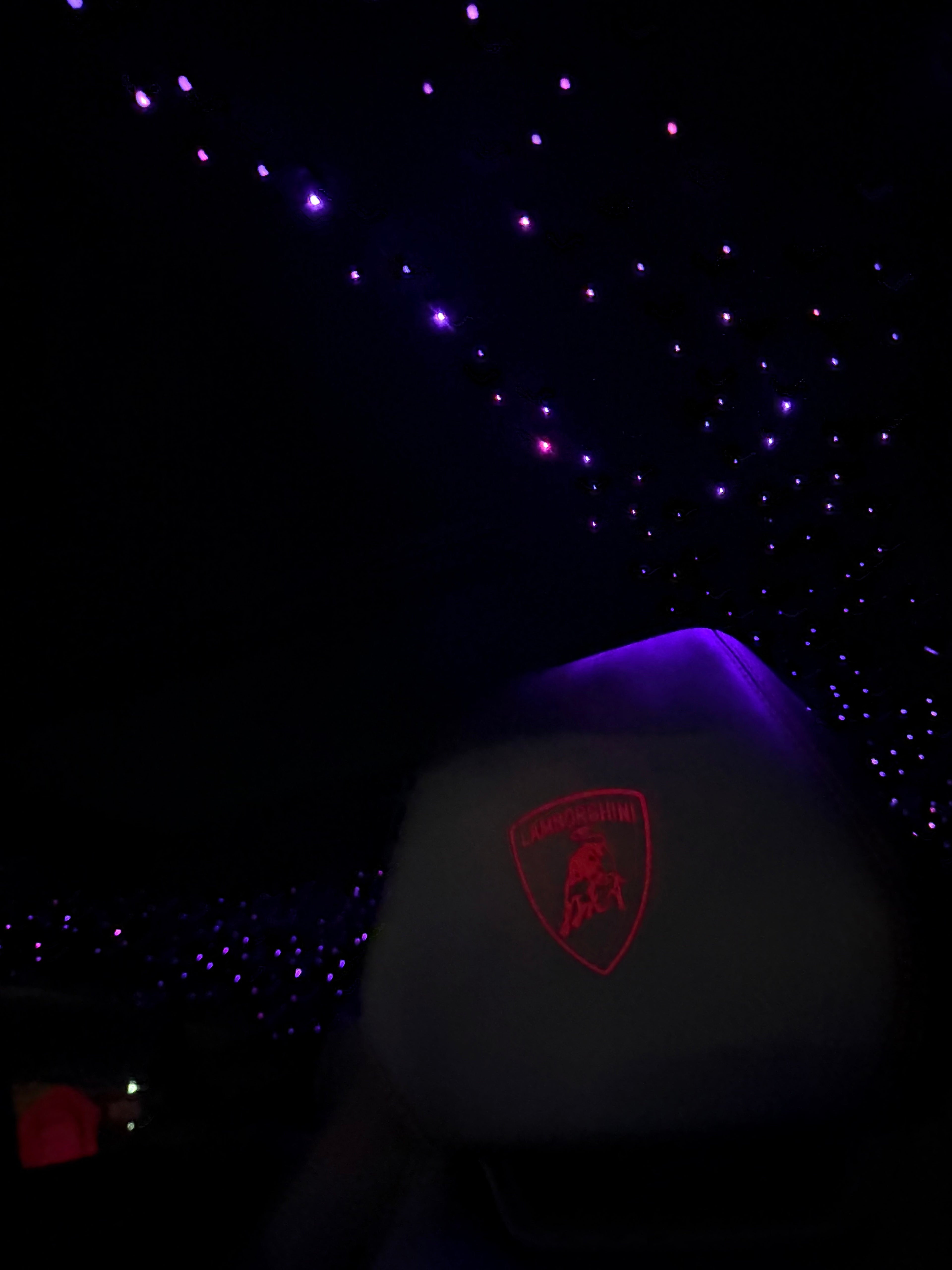 Car headrest with a logo against a starry night sky