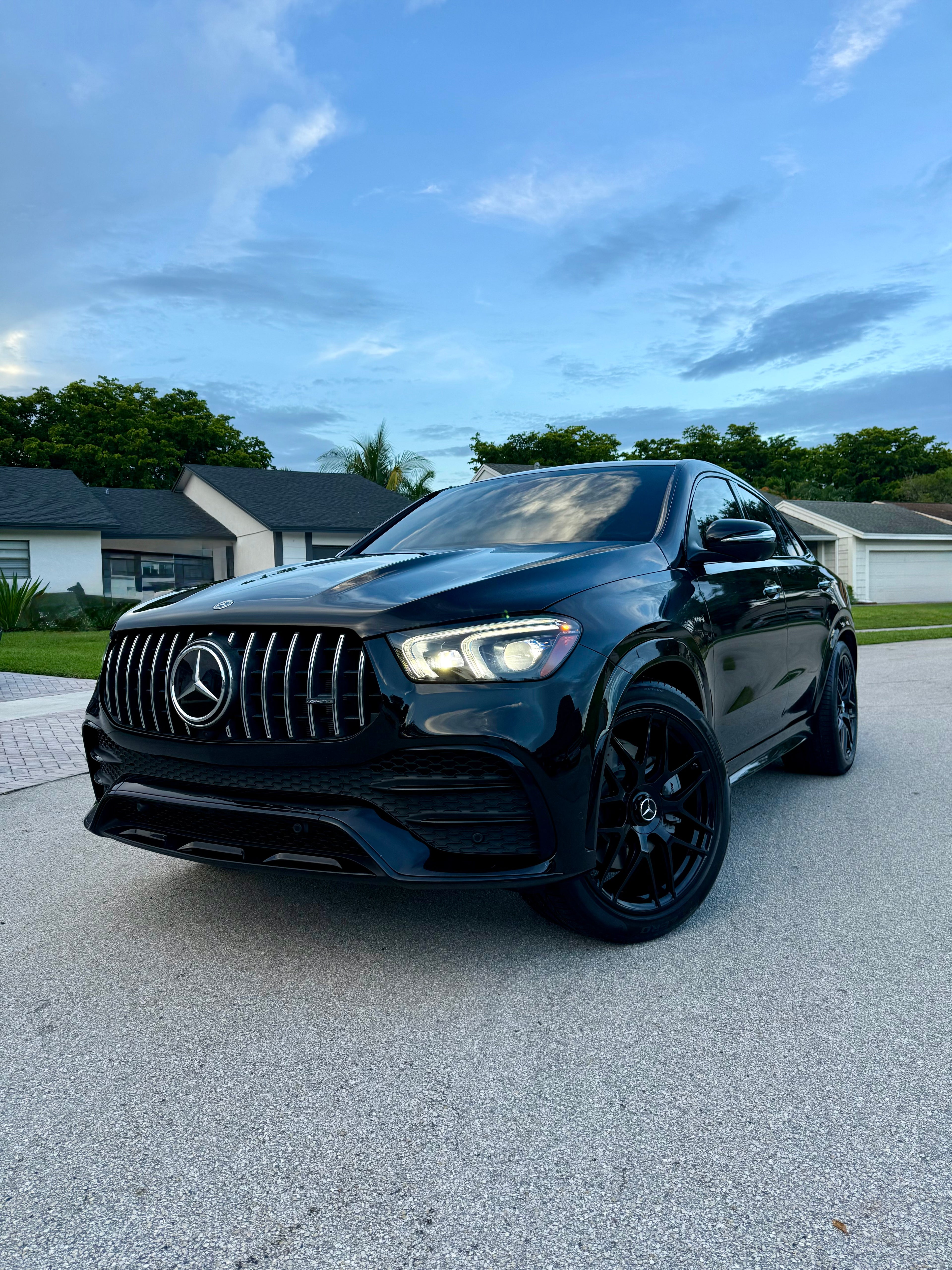 Black Mercedes-Benz SUV parked on a driveway with a clear sky background