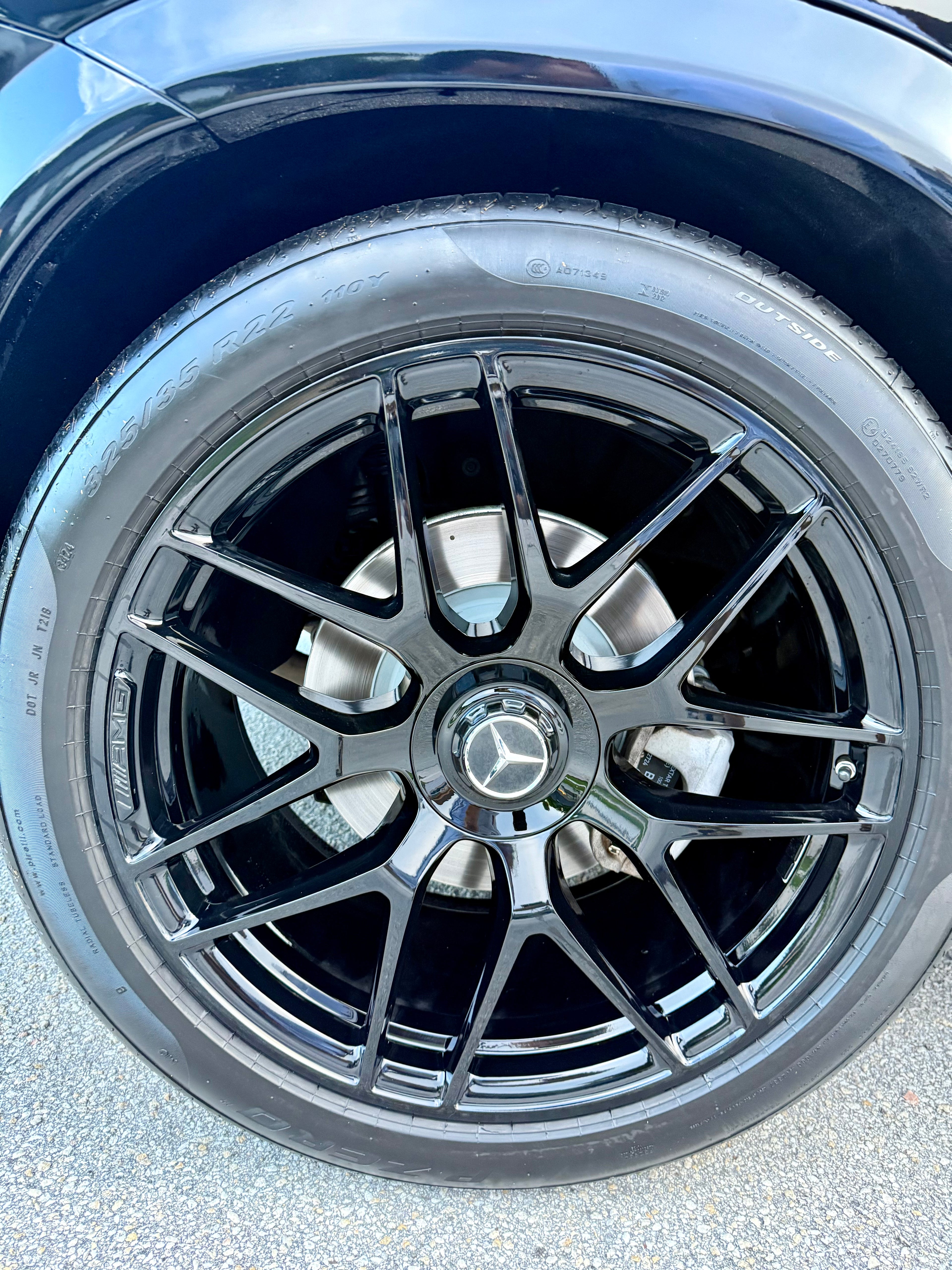 Close-up of a car wheel with a Mercedes-Benz logo on a black rim.