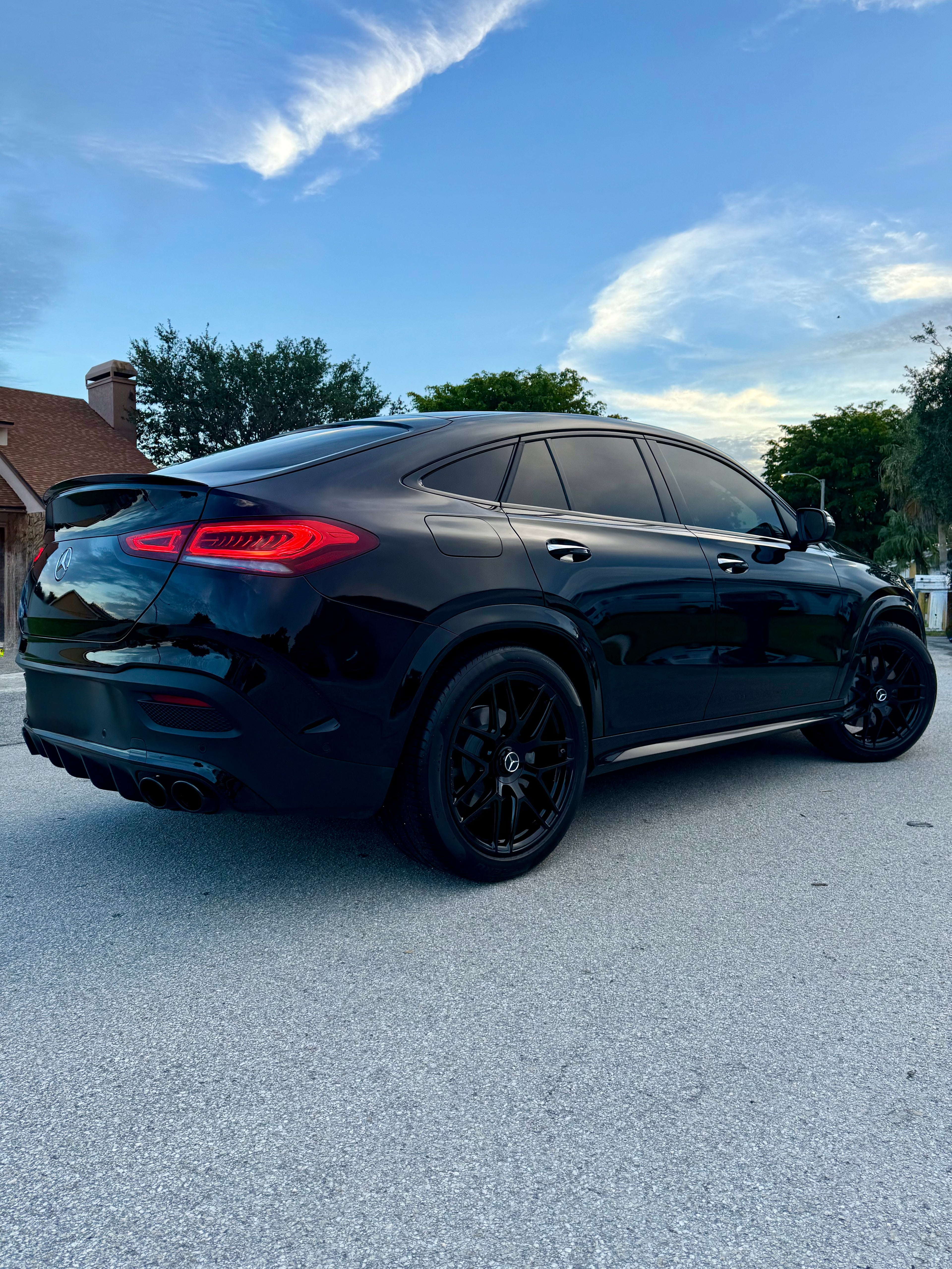 Black SUV parked on a street with a clear sky