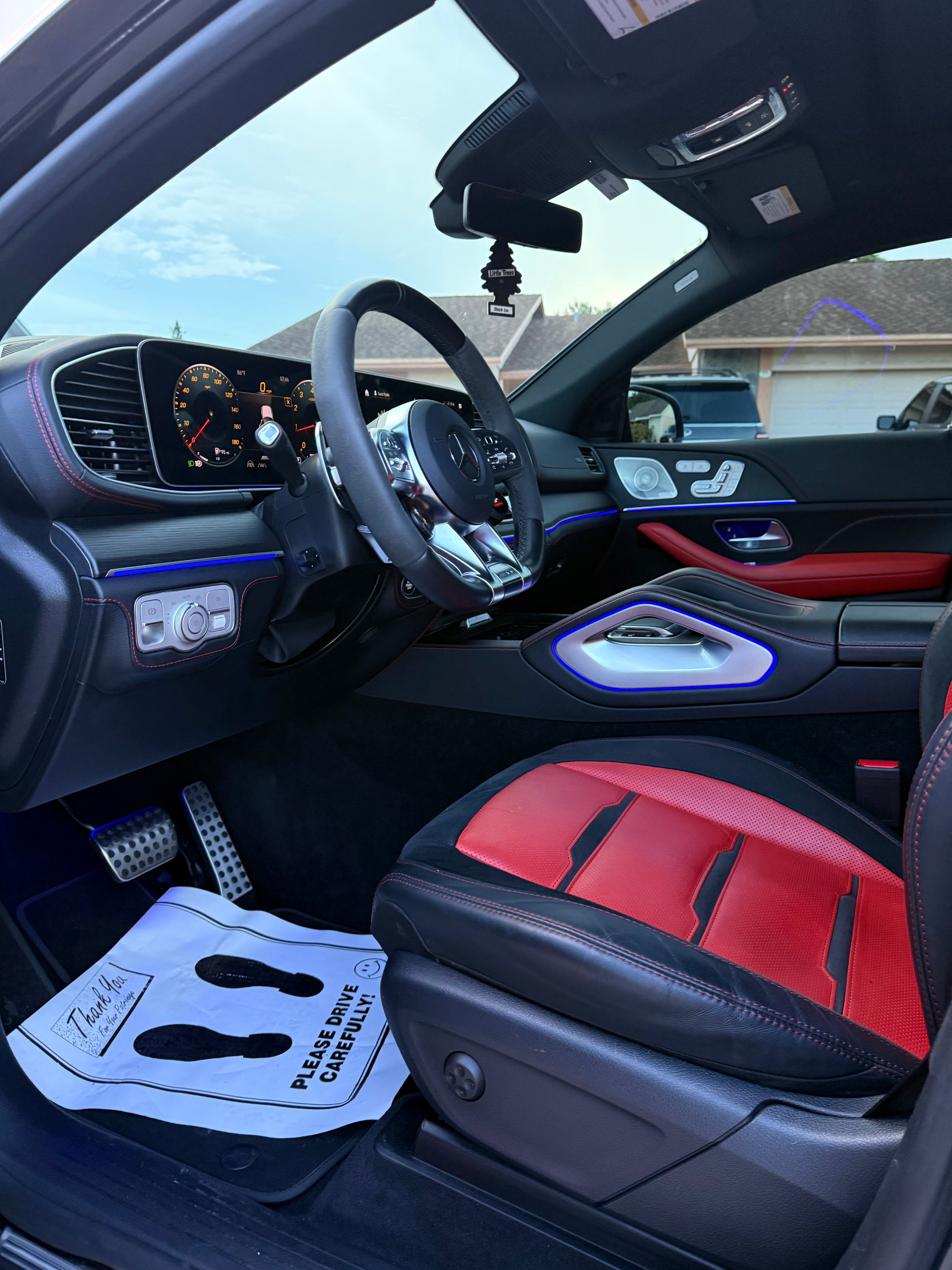 Car interior with red and black seats and a clean aesthetic.