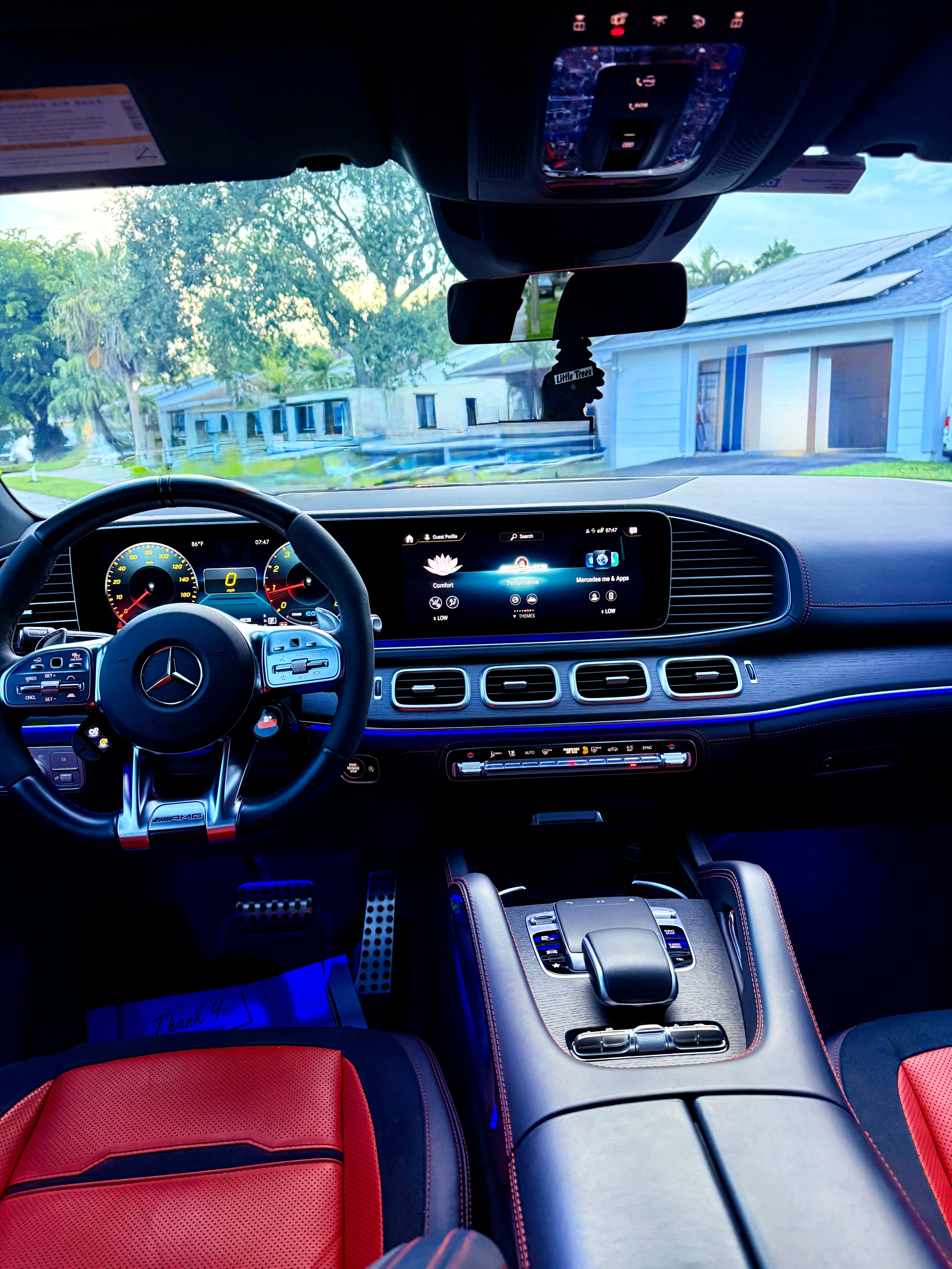 Luxury car interior with red leather seats and modern dashboard.