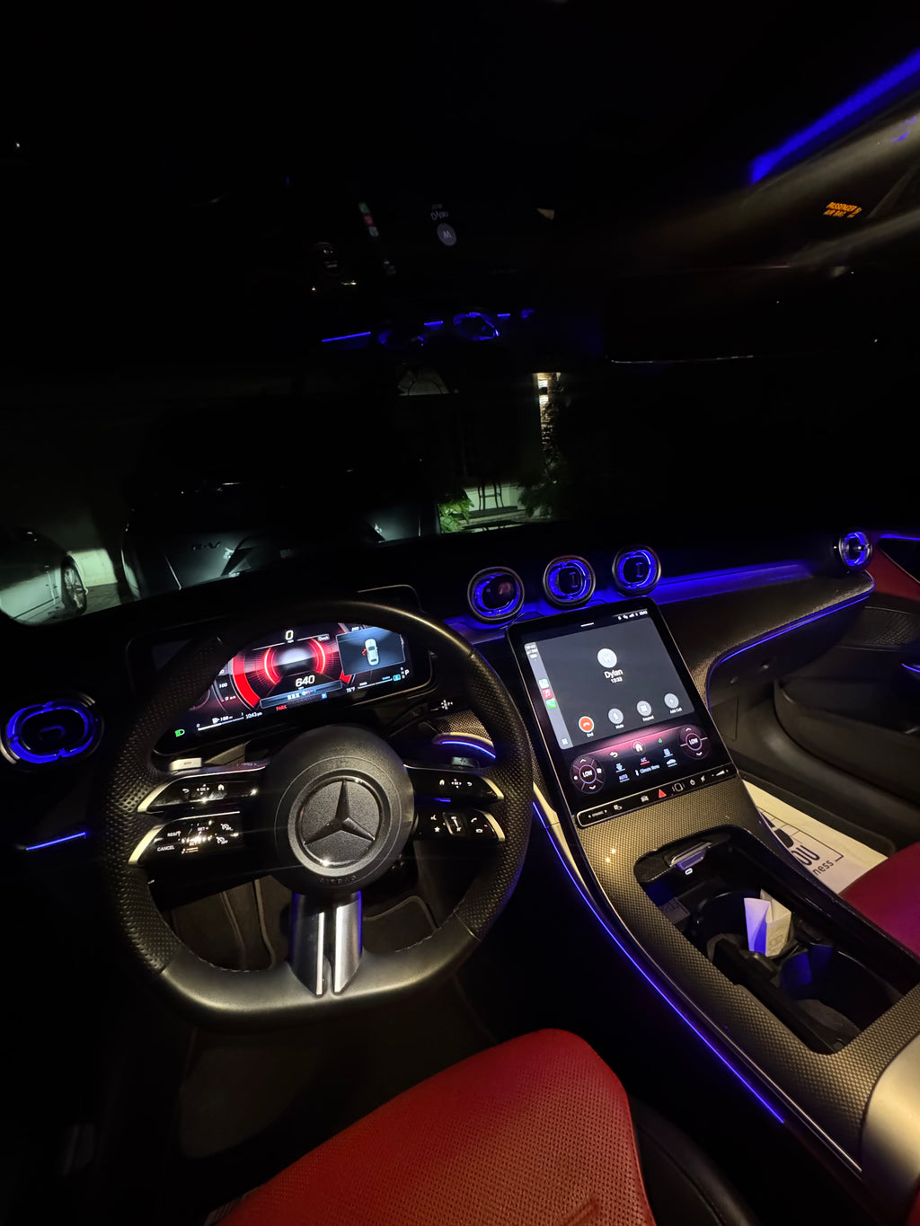 Car interior with steering wheel and dashboard in a dark setting