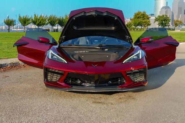 Red sports car with open doors on a city street