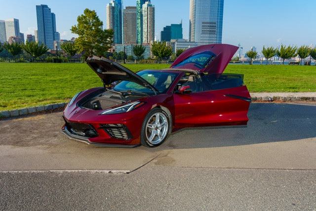 Red sports car with open doors on a city street