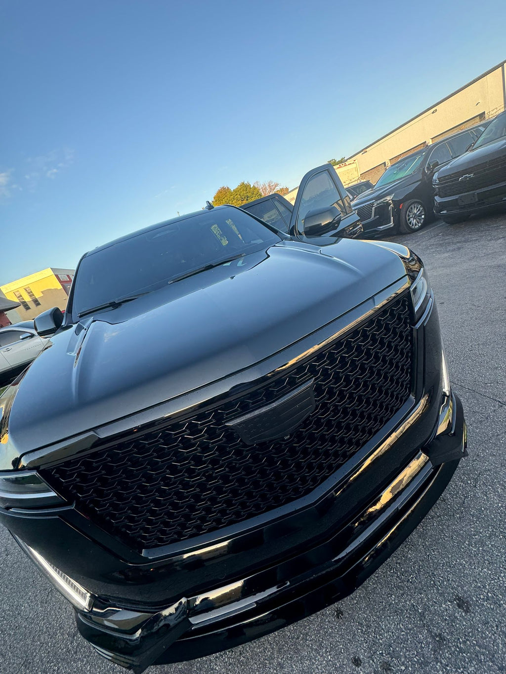Black car parked in a lot with clear sky