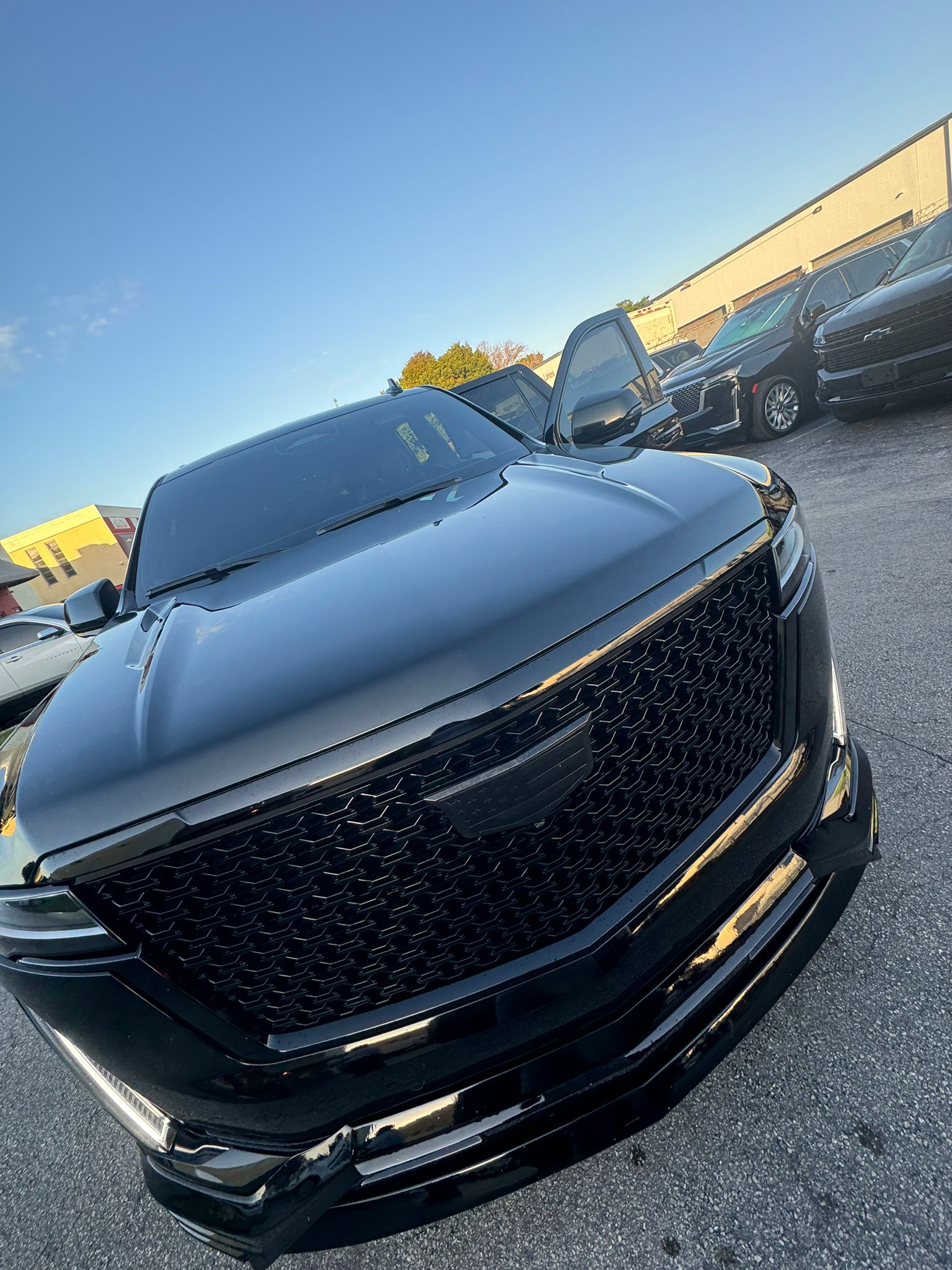 Black car parked in a lot with clear sky