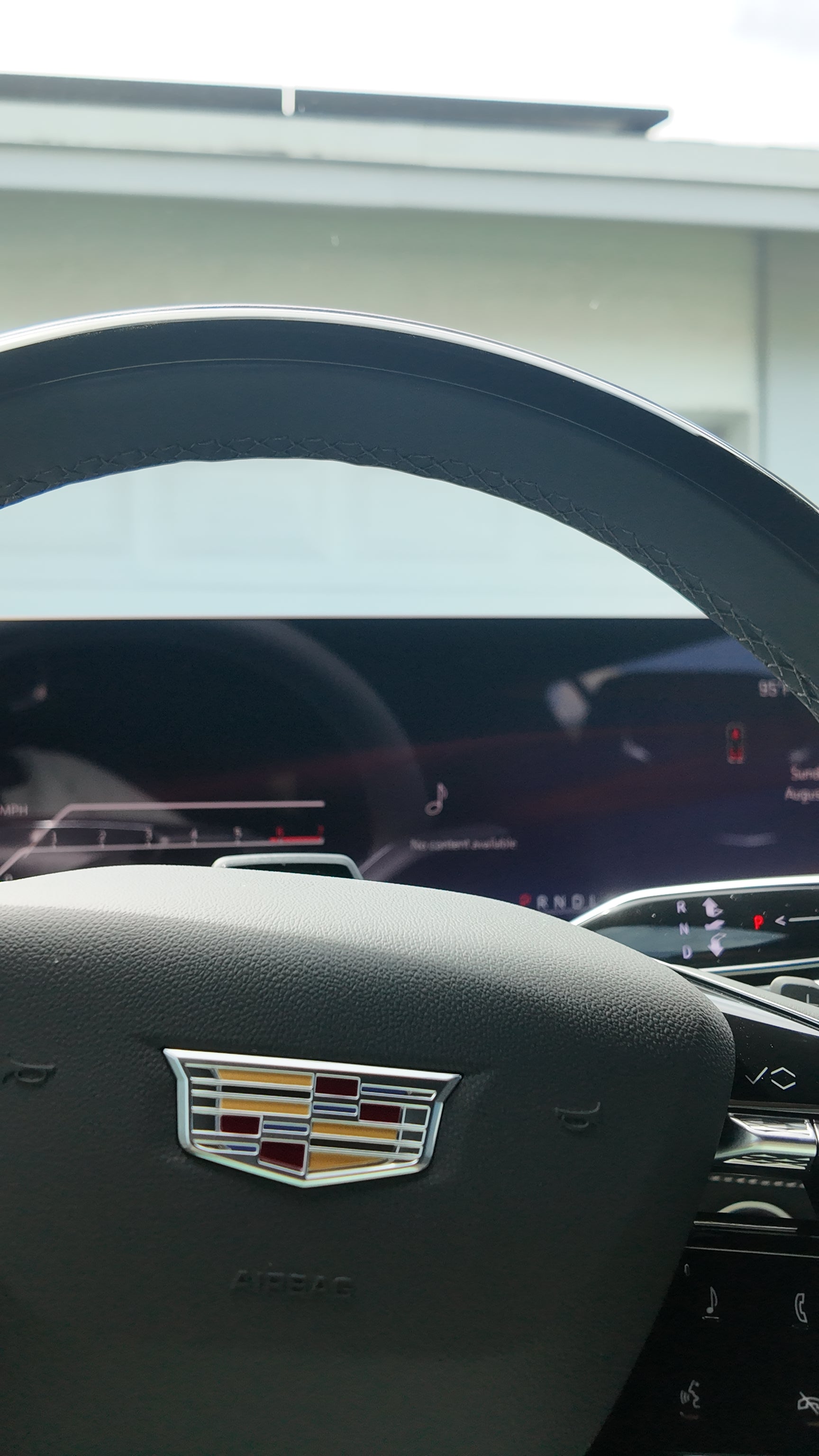 Cadillac logo on a car dashboard with a blurred background