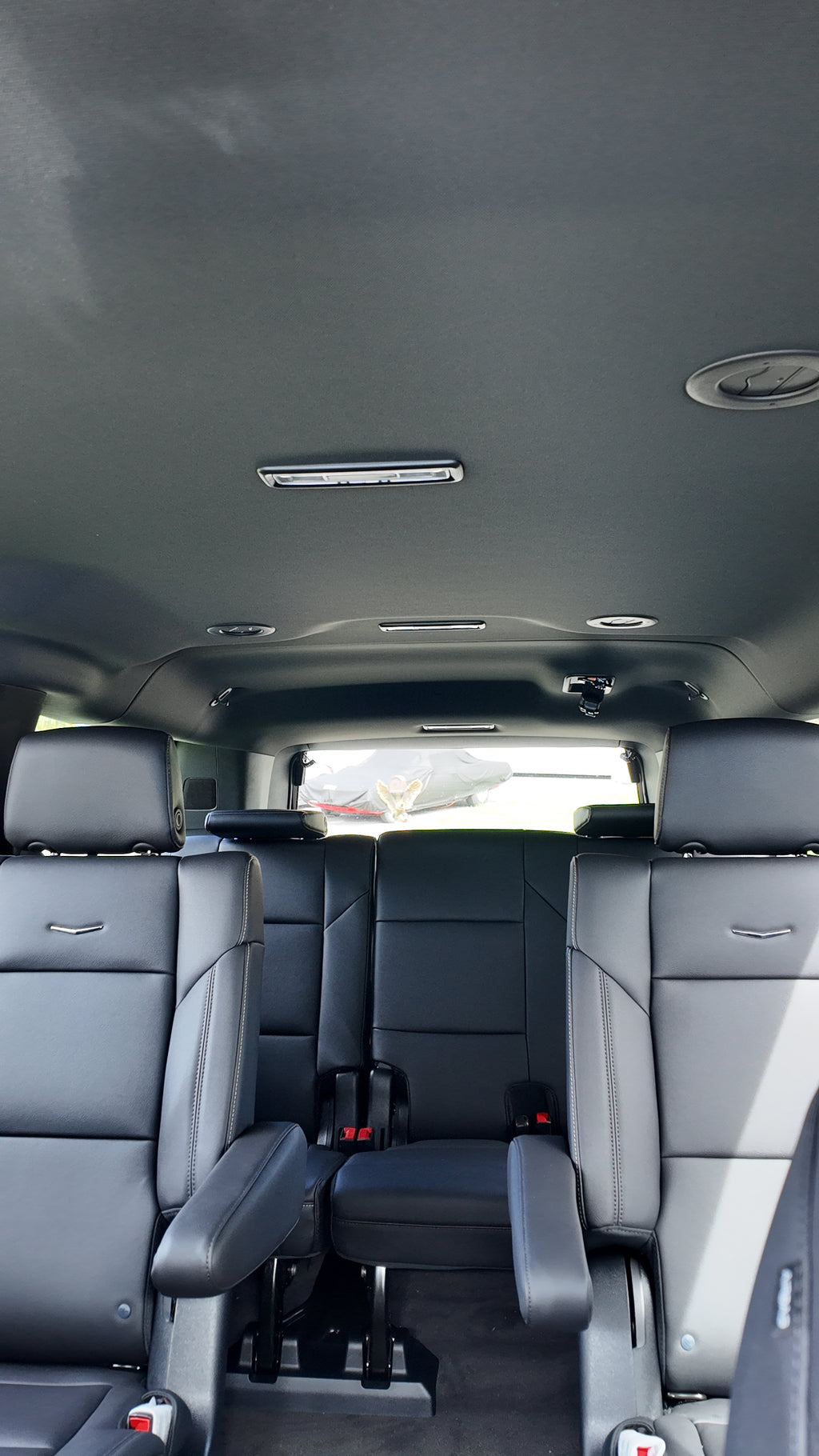 Interior of a vehicle with gray seats and a dark ceiling.
